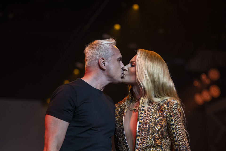 David Blond, left, and Phillipe Blond, right, kiss at The Blonds fashion show at Spring Place on Wednesday, Sept. 14, 2022, in New York. (AP Photo/Brittainy Newman)