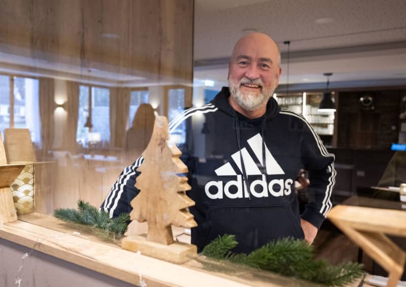 Restaurateur Wolfgang Ewerts stands in the now renovated dining room of his inn. He often shows people images of the extent of the destruction up and down the region. Boris Roessler/dpa