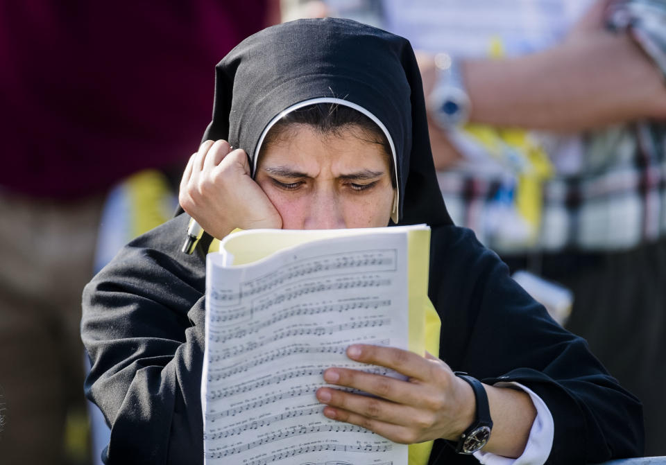 A nun reads through some papers as she waits for Pope Francis to celebrate a Mass in Monza, 30 kilometers north of Milan, Italy, as part of his one-day pastoral visit to Monza and Milan, Italy’s second-largest city, Saturday, March 25, 2017. Pope Francis focused his one-day visit Saturday to the wealthy northern Italian city of Milan on those marginalized by society, visiting families in a housing project and exhorting clergy and nuns gathered in a cathedral to minister to the peripheries. (AP Photo/Giuseppe Aresu)