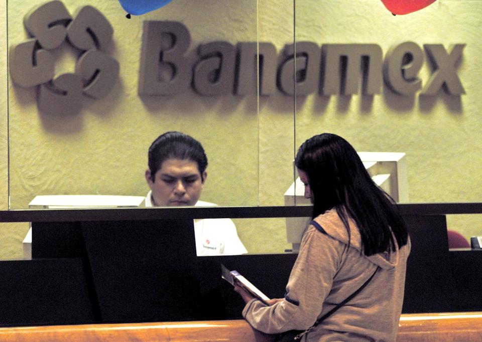 Una mujer realiza transacciones bancarias en una oficina del Grupo Financiero Banamex, en Ciudad de México (AFP | Ramon Cavallo)