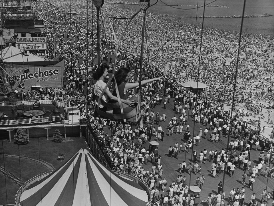 Two women ride the ferris wheel at Coney Island in the year 1900.