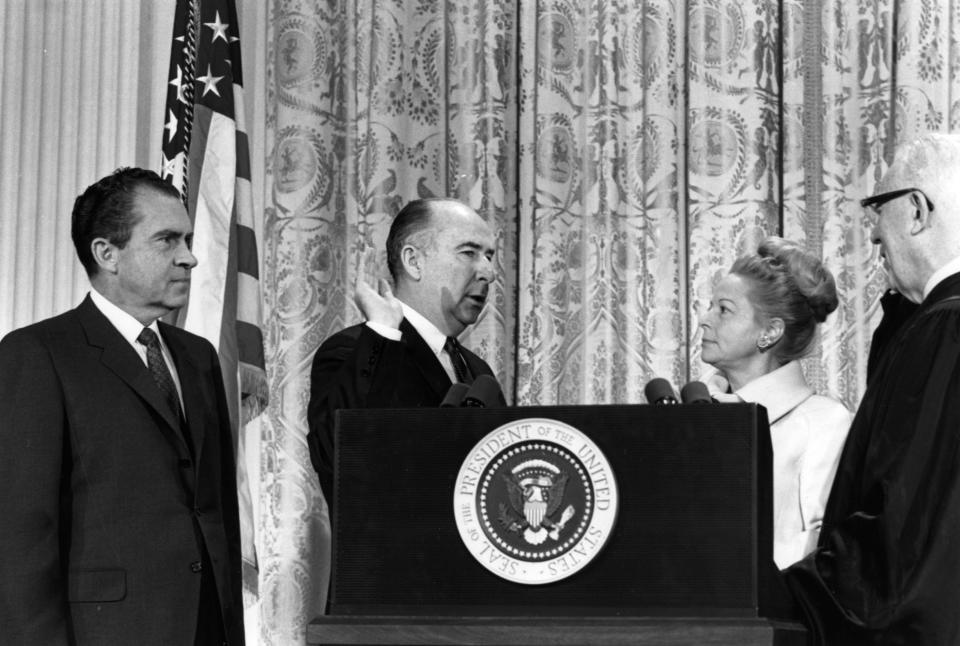 Attorney General John Mitchell is sworn in, as President Nixon and Mitchell's wife Martha look on.