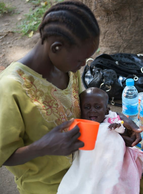 A mother feeds her child suffering from malnutrition on October 14, 2014 at the Al Sabbah Children's hospital in Juba