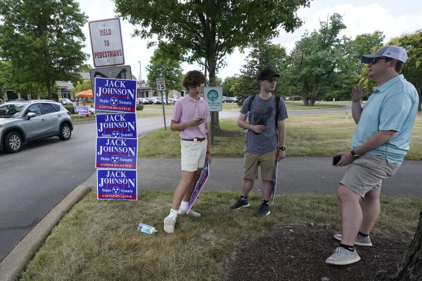 Lee Hobbs, right, a campaign staffer for state Sen. Jack Johnson, talks with campaign volunteers Fletcher Thomas, left, and Tom Pancione, center, outside the early voting site at the Brentwood Library on the first day of early voting Friday, July 15, 2022, in Brentwood, Tenn. GOP lawmakers redistricted the left-leaning city of Nashville early this year, splitting its one seat into three to help Republicans gain a seat. (AP Photo/Mark Humphrey)