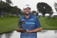 Marc Leishman of Australia holds up the winner's trophy after winning the Farmer's Insurance Open at the Torrey Pines Golf Course Sunday Jan. 26, 2020, in San Diego. (AP Photo/Denis Poroy)