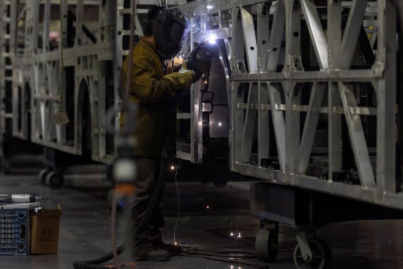 A welder works building a bus frame at the BYD electric bus factory in Lancaster, California