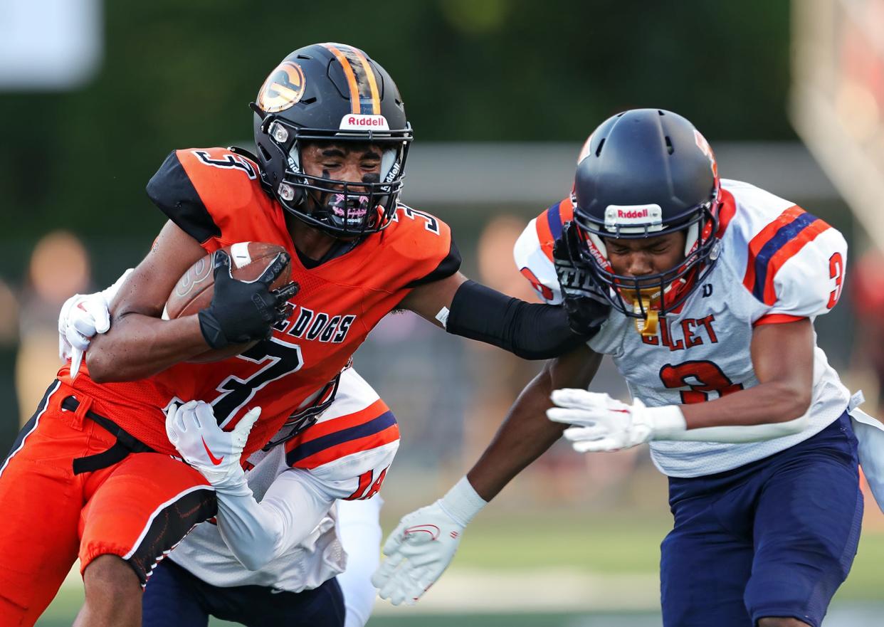 Green wide receiver Antonio Martin, left, stiff arms Marquis Sims as he runs for yards after a catch during the first half of a high school football game, Friday, Aug. 19, 2022, in Green, Ohio.