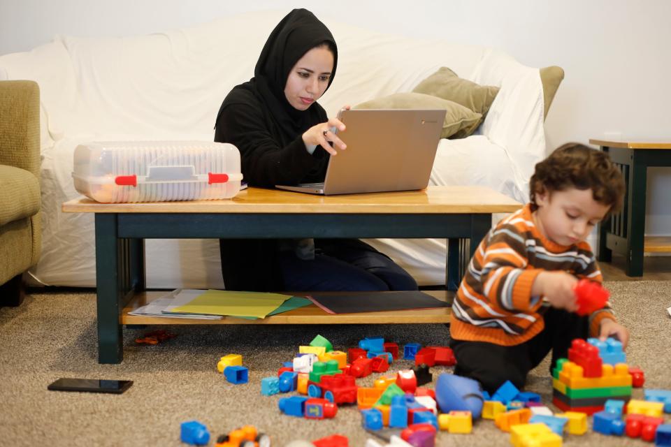 Khalida Hakimi looks online for ways to get her doctors equivalency in the United States, as her son, Ferdous Omar, 2, plays in the foreground. Afghanistan nationals Khalid Omar, his wife, Khalida Hakimi, and son, Ferdous Omar, have been living in New Bedford since February.