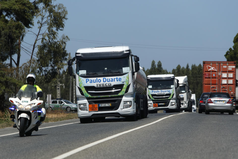 Police escorts a convoy of tanker trucks leaving a fuel depot in Aveiras, outside Lisbon, Tuesday, Aug. 13, 2019. Soldiers and police officers are driving tanker trucks to distribute gas in Portugal as an open-ended truckers' strike over pay enters its second day. The government has issued an order allowing the army to be used. (AP Photo/Armando Franca)