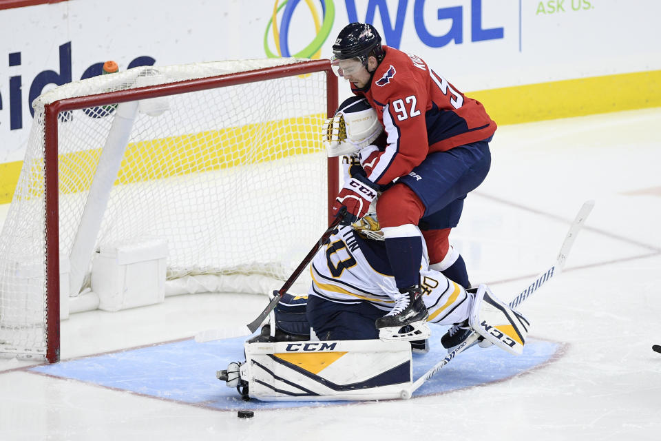Washington Capitals center Evgeny Kuznetsov (92), of Russia, battles for the puck against Buffalo Sabres goaltender Carter Hutton (40) during the third period of an NHL hockey game, Saturday, Dec. 15, 2018, in Washington. (AP Photo/Nick Wass)
