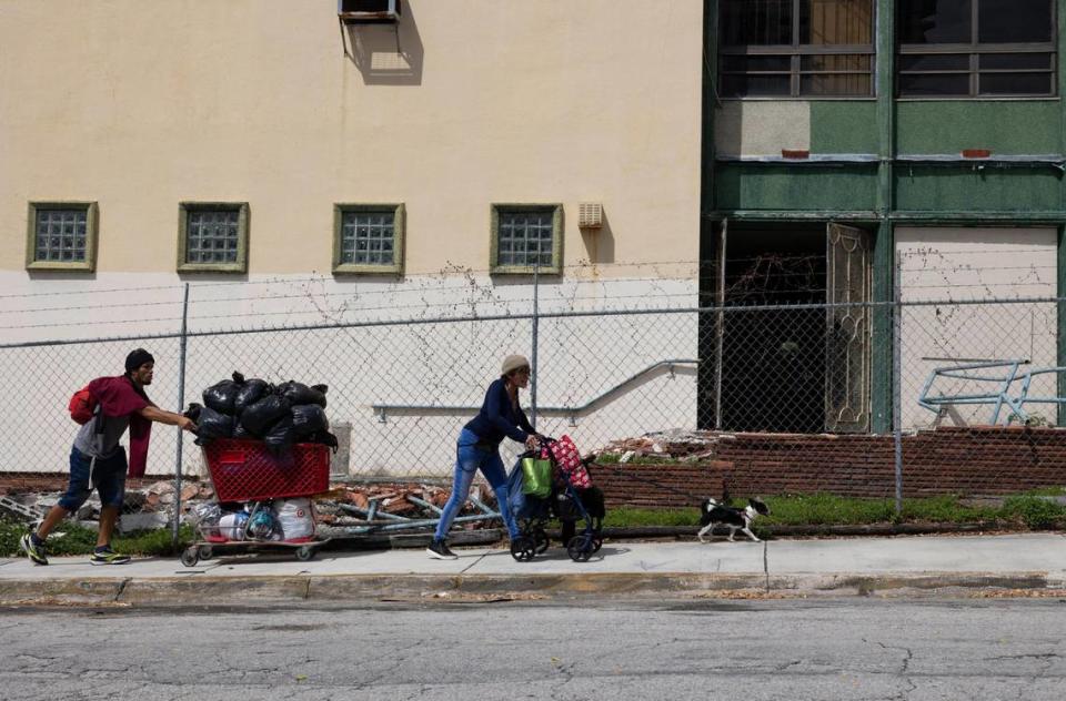Eli, a veteran, center, and her dog and partner search for a new area to camp with all of their belongings after City of Miami Police told them to move and vacate the area under a Flagler Street bridge on Thursday, Feb. 29, 2024, by the river in Miami. According to the group they camp with, the homeless shelters in the area are all full. Even if they weren’t, they are only allowed to take a few of their belongings inside with them to an emergency shelter, so when they come back outside, all of their belongings are either picked through or thrown away, which makes sleeping on the street the next night harder.