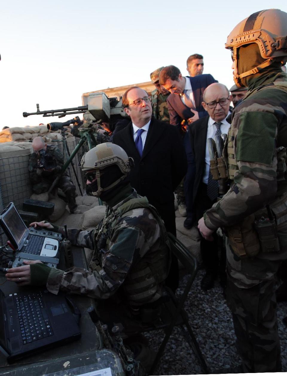 French President Francois Hollande and French defense minister Jean-Yves Le Drian, right, meet with French soldiers as they visit a military outpost on the outskirts of the Islamic State-held city of Mosul, outside the Kurdish city of Irbil, Iraq, Monday, Jan. 2, 2017. Hollande is in Iraq for a one-day visit. (AP Photo/ Christophe Ena, Pool)