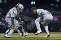 Oakland Athletics starting pitcher Jesus Luzardo, right, and Athletics catcher Aramis Garcia, left, are unable to make a play on a bunt single by Arizona Diamondbacks' Zac Gallen during the second inning of a baseball game Tuesday, April 13, 2021, in Phoenix. (AP Photo/Ross D. Franklin)