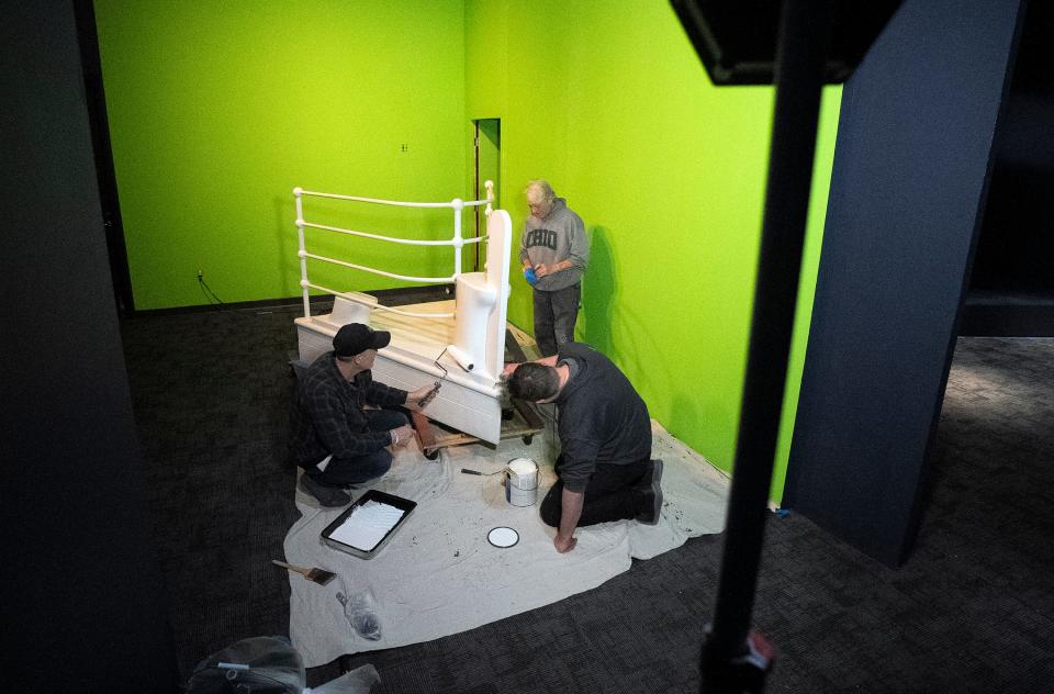 Workers paint a replica of the bow of the Titanic that is part of "Titanic: The Artifact Exhibition" at the Center of Science and Industry (COSI).