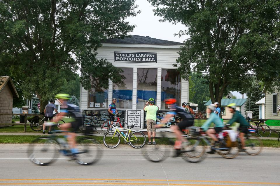 Riders get photos with the world's largest popcorn ball as RAGBRAI rolls out of Sac City, Monday, July 26, 2021.