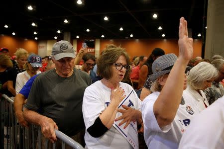 Supporters of Republican presidential nominee Donald Trump pray during the invocation during a campaign rally in Phoenix, Arizona, U.S., August 31, 2016. REUTERS/Carlo Allegri