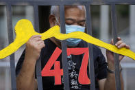 A protester stands behind a mock prison during a protest against an election committee that will vote for the city's leader in Hong Kong Sunday, Sept.19, 2021. Hong Kong's polls for an election committee that will vote for the city's leader kicked off Sunday amid heavy police presence, with chief executive Carrie Lam saying that it is "very meaningful" as it is the first election to take place following electoral reforms. (AP Photo/Vincent Yu)