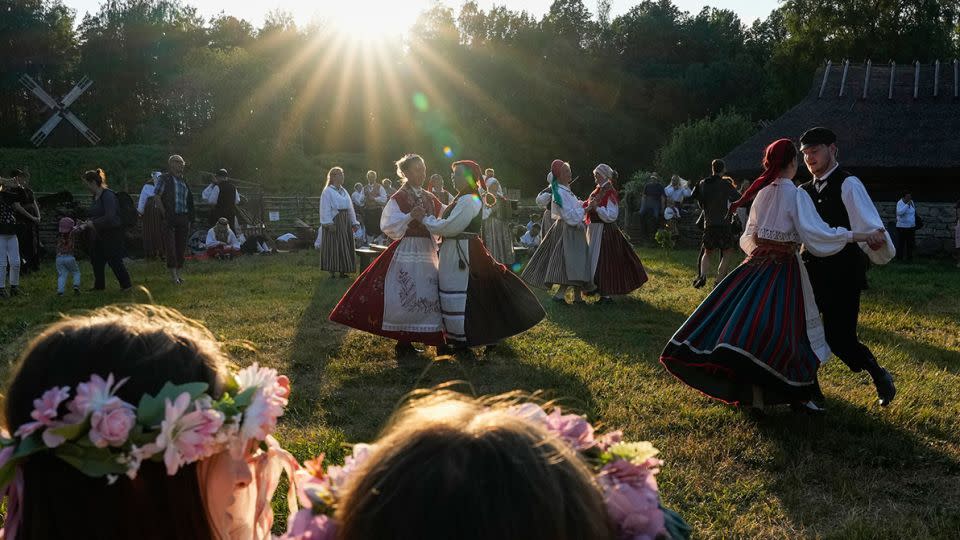 People dressed in traditional clothing dance during celebrations of Midsummer Day at the Open Air Museum in Tallinn, Estonia, on June 23, 2023. - Pavel Golovkin/AP