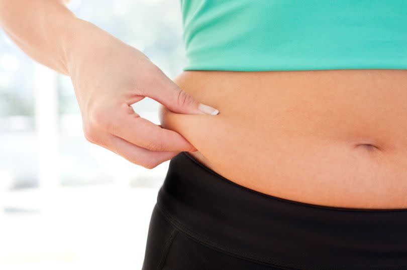 Woman pinching fat around her waist