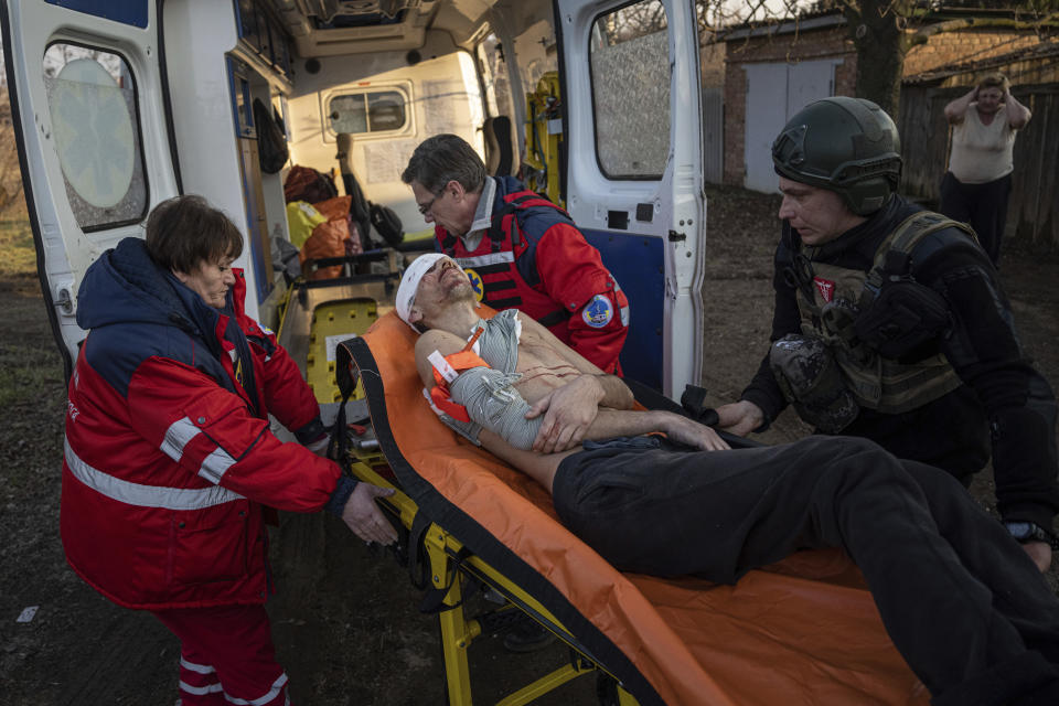 Paramédicos y policías ucranianos transportan en camilla al residente local Oleksandr Nikiforov, de 49 años, que resultó herido por los ataques rusos, en una zona habitacional cerca de Kostiantynivka, Ucrania, el viernes 10 de marzo de 2023. (AP Foto/Evgeniy Maloletka)