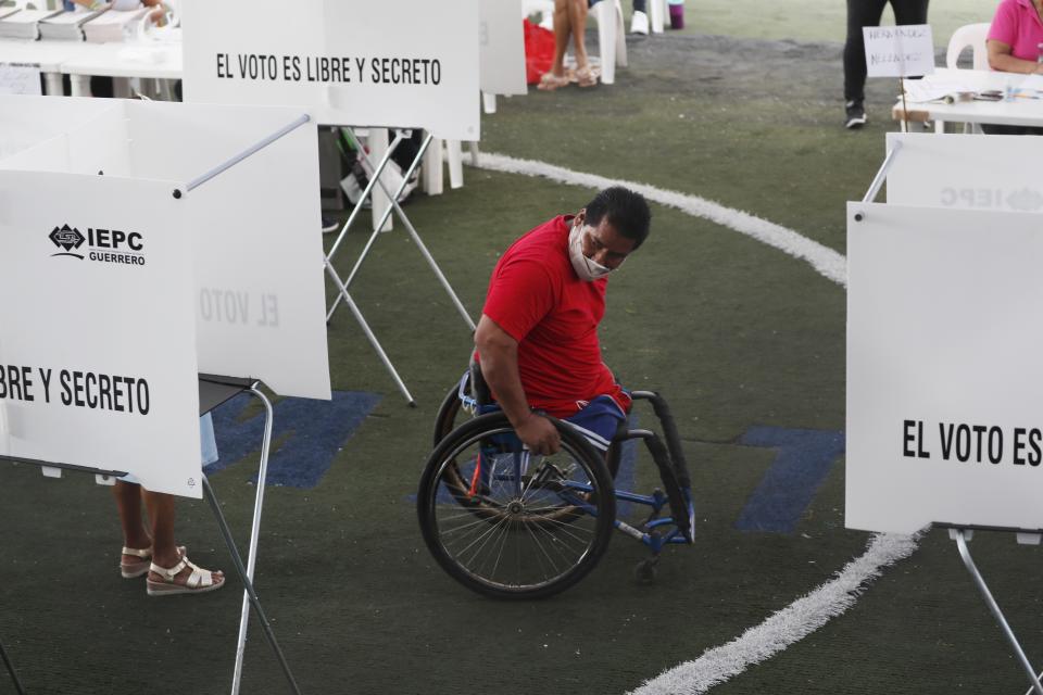 A voter looks for his at booth at a polling station during mid-term elections in Acapulco, Mexico, Sunday, June 6, 2021. Mexicans are elected the entire lower house of Congress, almost half the country's governors and most mayors on Sunday. (AP Photo/Fernando Llano)
