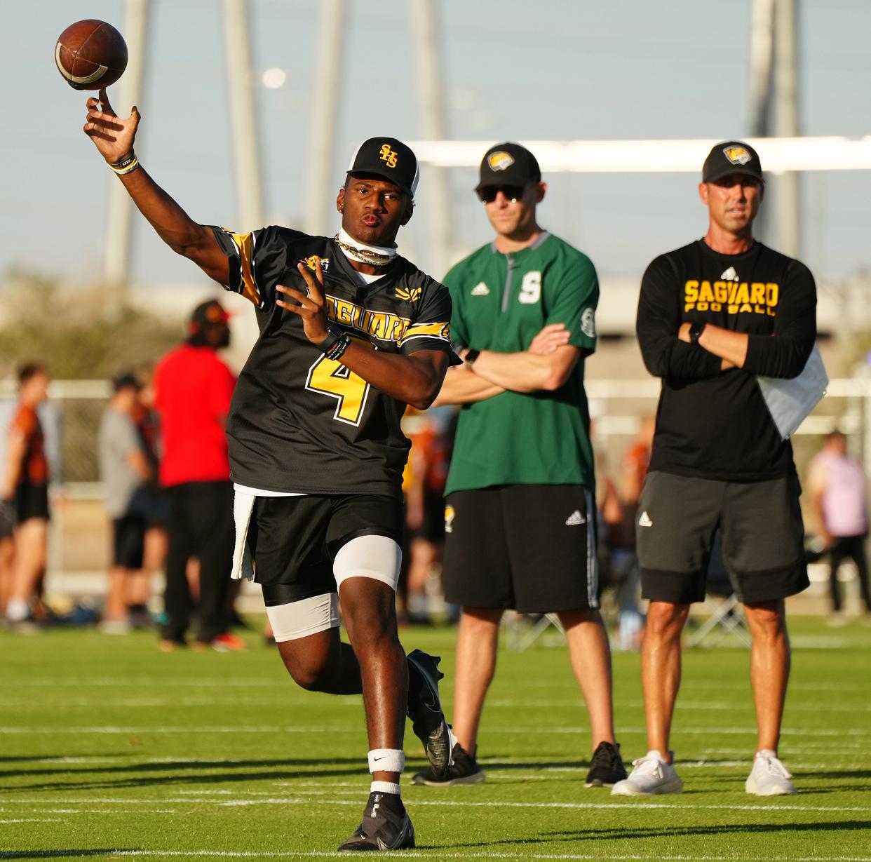 June 2, 2022; Tempe, Arizona; USA; Saguaro quarterback Devon Dampier (4) throws as his head coach Jason Mohns watches during a 7 on 7 tournment, an ASU High School Football Showcase. Mandatory Credit: Patrick Breen-Arizona Republic