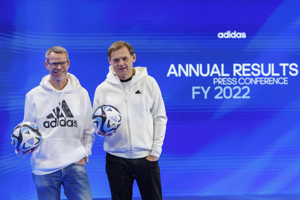 Bjoern Gulden, CEO of sporting goods manufacturer adidas AG, right, and CFO Harm Ohlmeyer hold the official match ball "OCEAUNZ" of the Women's World Cup in Australia and New Zealand 2023 in his hands on the sidelines of the company's annual press conference in Herzogenaurach, Germany, Wednesday, March 8, 2023. (Daniel Karmann/dpa via AP)