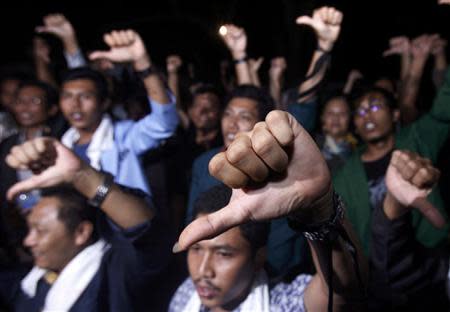Anti-corruption activists chant slogans and gesture as they watch a live television broadcast of a speech by Indonesian President Susilo Bambang Yudhoyono in Jakarta in this November 23, 2009 file photo. REUTERS/Crack Palinggi