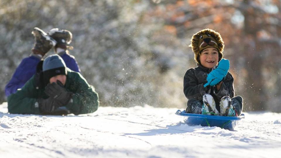 Jaan Ewing, 7, and Max Winzelberg, 17, sled down a hill on N. Boundary St. in Chapel Hill, N.C. on a snowy Saturday morning, Jan. 22 2022.