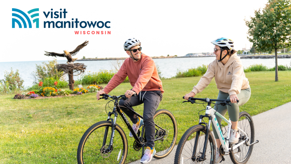 Visit Manitowoc’s new logo, as featured on a publicity item of people biking on Mariners Trail.