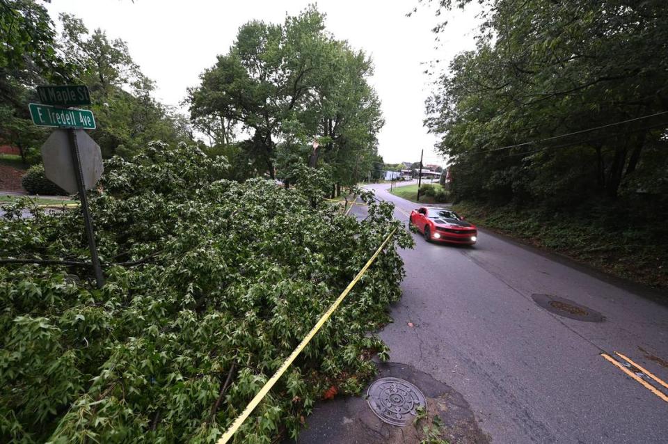 A fallen tree at the intersection of E. Iredell Ave. and N. Maple Street forces traffic to move left of center of the line following a storm that passed through the area on Monday, August 7, 2023 in Mooresville, NC.