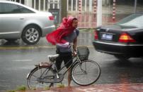 A man pushes his bicycle against the wind as Typhoon Usagi approaches Shantou, Guangdong province, September 22, 2013. REUTERS/Stringer