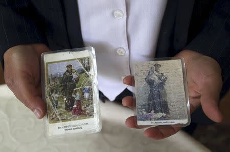 Ruzica Barbaric, 63, who said she was raped during the 1991-95 war of independence from Yugoslavia, shows pictures of saints in Vukovar, east Croatia, April 19, 2015. REUTERS/Antonio Bronic