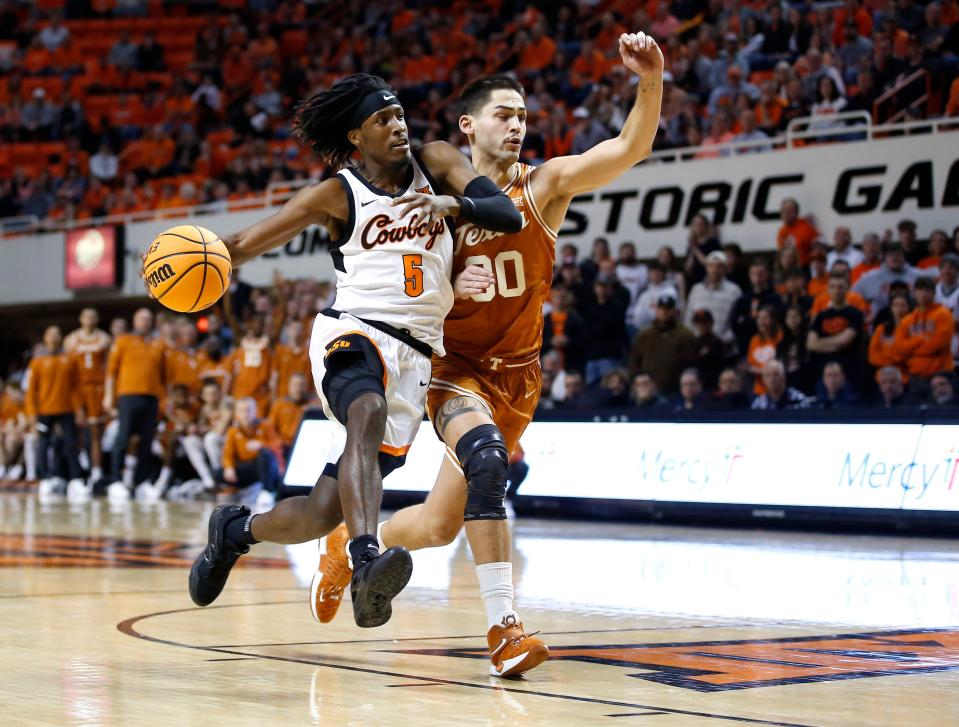 Oklahoma State's Caleb Asberry (5) drives to to the basket as Texas's Brock Cunningham (30) defends in the second half during the college basketball between the Oklahoma State Cowboys and the Texas Longhorns at Gallagher-Iba Arena in Stillwater, Okla., Saturday, Jan.7, 2023. 