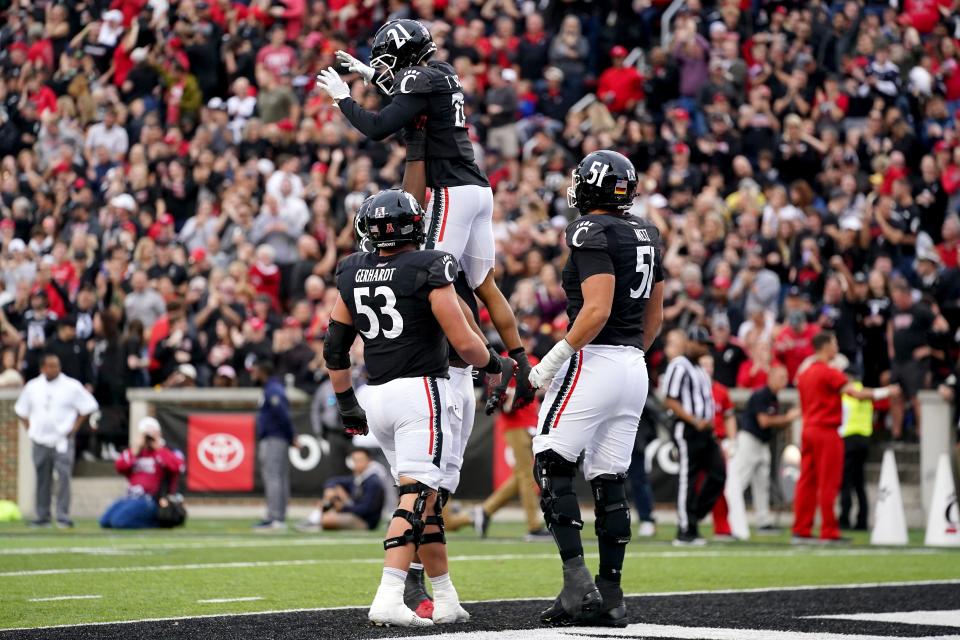 Cincinnati Bearcats wide receiver Tyler Scott (21) is congratulated on a touchdown catch and run in the second quarter during a college football game against the Navy Midshipmen, Saturday, Nov. 5, 2022, at Nippert Stadium in Cincinnati. 