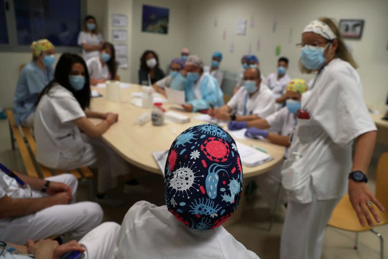 A healthworker wearing a head protection with drawings of viruses takes part in the emergency unit morning meeting as the spread of the coronavirus disease (COVID-19) continues, at Infanta Sofia University hospital in Madrid