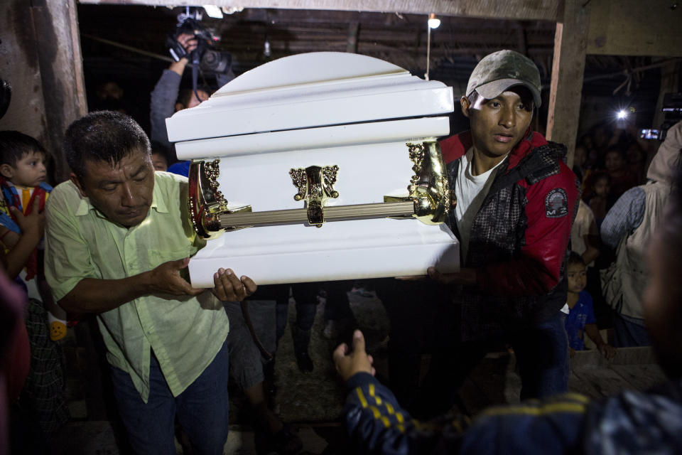 Neighbors carry the coffin that contain the remains of 7-year-old Jakelin Caal Maquin into her grandparent's home in San Antonio Secortez, Guatemala, Monday, Dec. 24, 2018. The body of a 7-year-old girl who died while in the custody of the U.S. Border Patrol was handed over to family members in her native Guatemala on Monday for a last goodbye. (AP Photo/ Oliver de Ros)