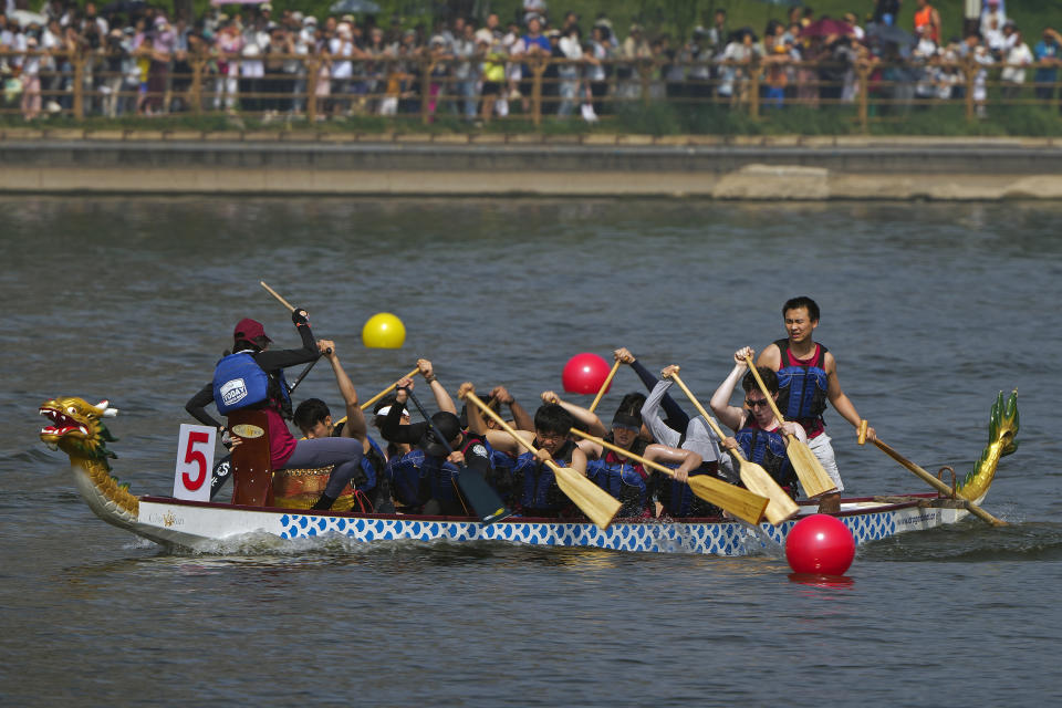 A team of dragon boat racers paddle their boat during the Dragon Boat Festival at a canal in Tongzhou, outskirts of Beijing, Monday, June 10, 2024. The Duanwu Festival, also known as the Dragon Boat Festival, falls on the fifth day of the fifth month of the Chinese lunar calendar and is marked by eating rice dumplings and racing dragon boats. (AP Photo/Andy Wong)