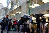 Apple customers wait in the rain outside the company's Australia's flagship store in the minutes leading up to the first sale of the iPhone 7 and Apple Watch Series 2 in Sydney, September 16, 2016. REUTERS/Steven Saphore FOR EDITORIAL USE ONLY. NO RESALES. NO ARCHIVES.