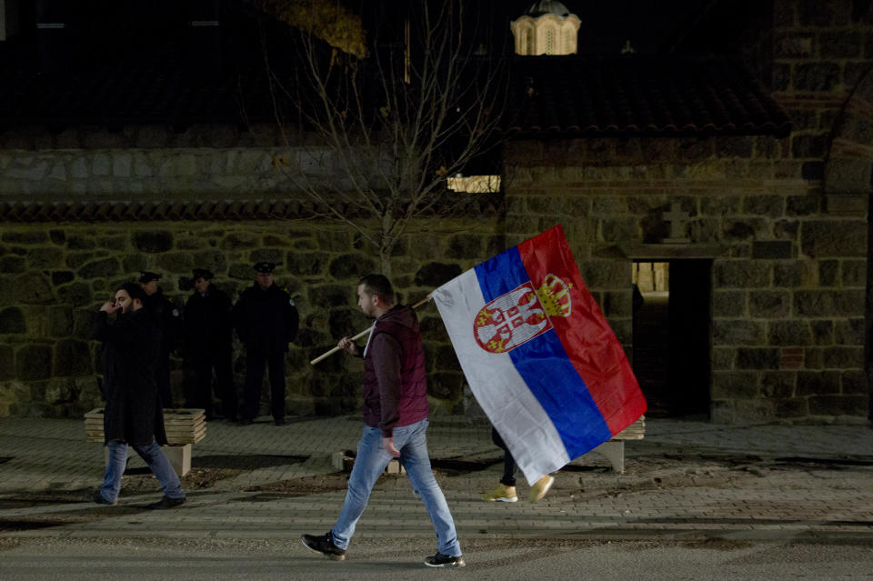 A Kosovo Serb protester carries a Serb flag and joins a demonstration against Serbian President Aleksandar Vucic in the town of Gracanica, Kosovo on Saturday, Feb. 9, 2019. Every Saturday thousands of opponents of Serbian president Aleksandar Vucic march in various cities and towns across Serbia. (AP Photo/Visar Kryeziu)