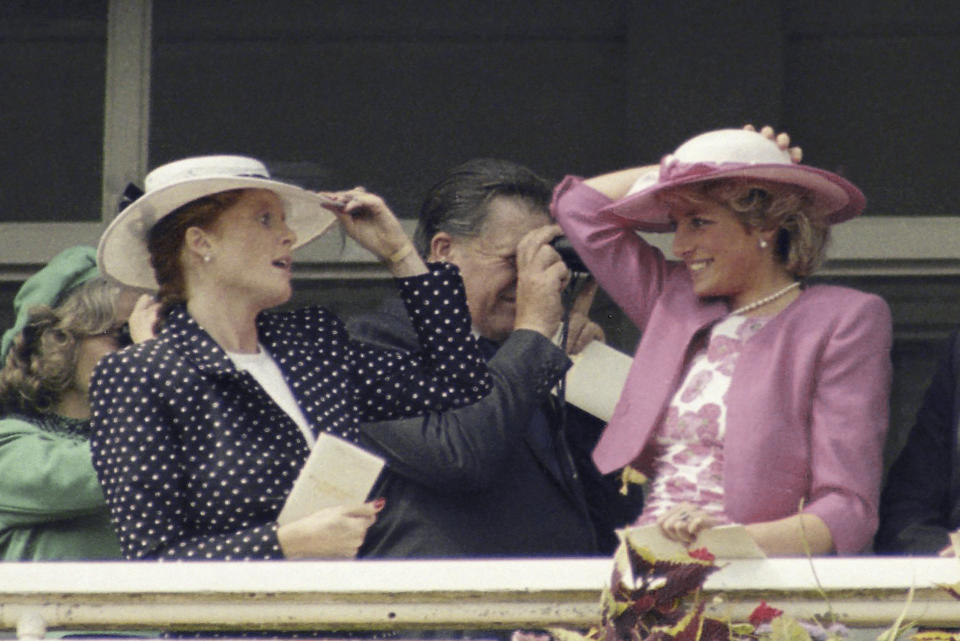 FILE - Britain's Princess of Wales, right, and the Duchess of York, hold on to their hats in windy condition while attending the running of the 1987 Derby at Epsom racecourse in England on Wednesday, June 3, 1987. (AP Photo, File)