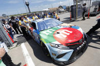 Kyle Busch's No. 18 car is pushed to the track by crew members before a practice run for a NASCAR Cup Series auto race at Kansas Speedway in Kansas City, Kan., Saturday, May 14, 2022. (AP Photo/Colin E. Braley)