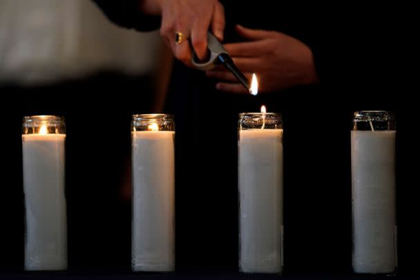 PHOTO: A event participant lights a memorial candle during an event of unity and healing at the Central Avenue Synagogue-Chabad in Highland Park for the victims of Monday's Highland Park's Fourth of July parade in Highland Park, Ill., July 7, 2022. (Nam Y. Huh/AP)