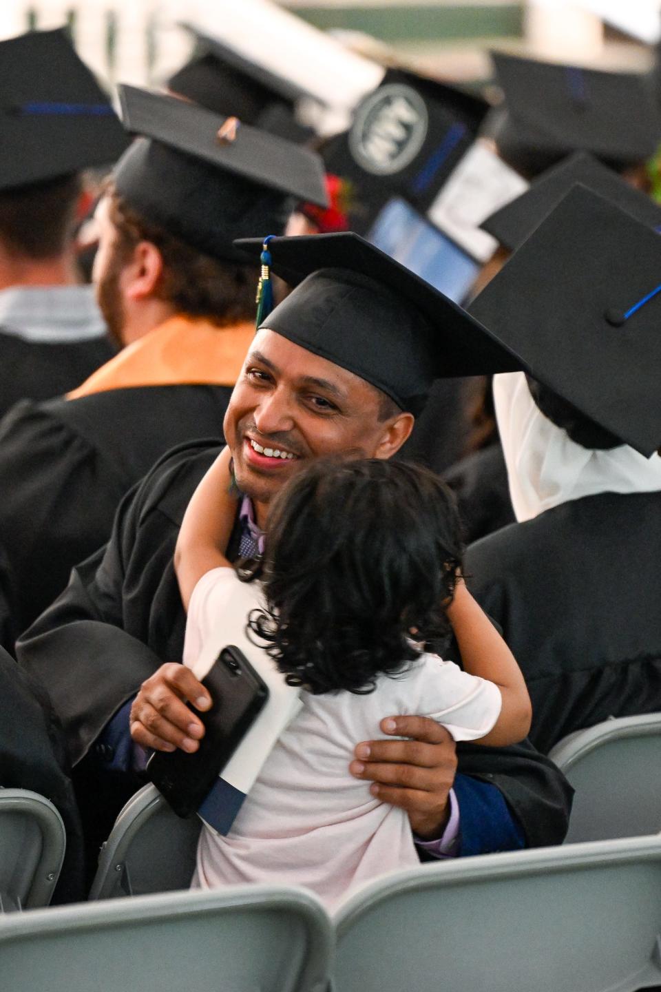 Raj Kumar gets a hug from his daughter, Neupane, during MassBay Community College's commencement exercises, May 23, 2024.