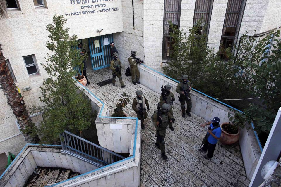 Israeli security personnel search a religious Jewish Yeshiva next to a synagogue, where a suspected Palestinian attack took place, in Jerusalem,