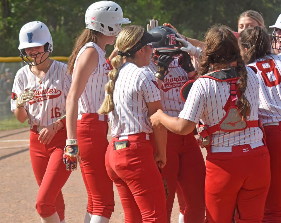 Coldwater senior Alexis Bills (center, helmet that says T2) is mobbed by her teammates after her three run home run to kick off the scoring Tuesday at Marshall