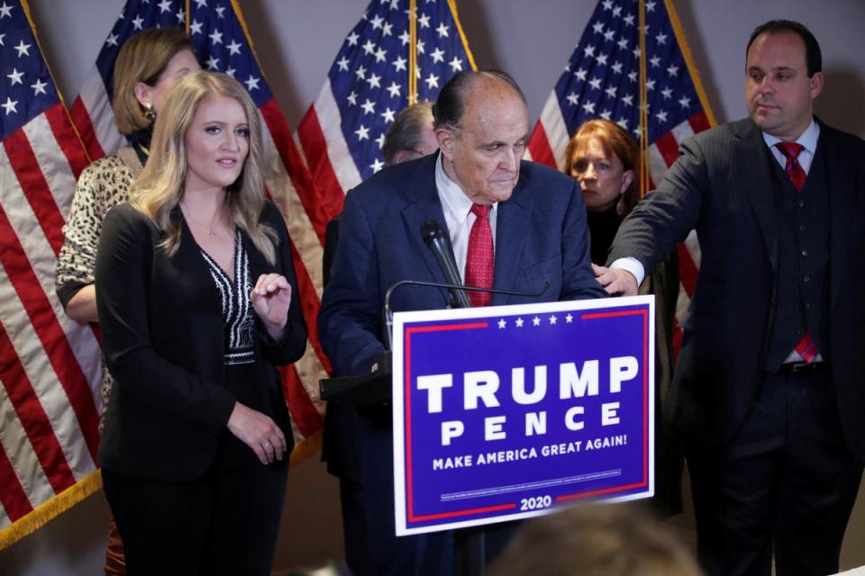 Rudy Giuliani speaks at a press conference next to Jenna Ellis, left, amplifying bogus fraud claims in the wake of the 2020 election (REUTERS)