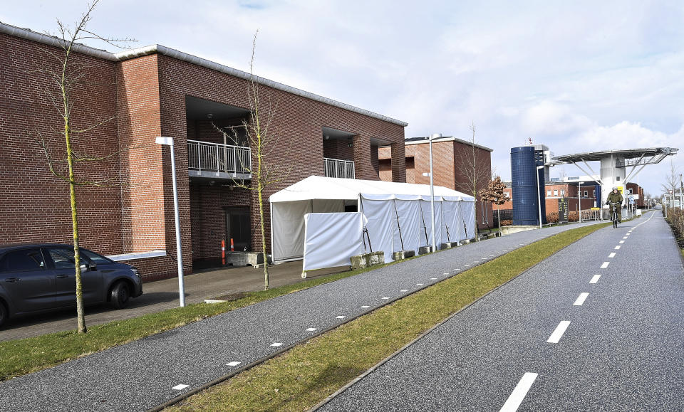 A tent serves as a drive-thru coronavirus testing facility at Aarhus University Hospital in Aarhus, Denmark, Monday March 9, 2020. Locals are able to drive though the tented corridor, and met by a hospital worker who performs the COVID-19 test without the driver leaving their car. (Ernst van Norde/Ritzau via AP)