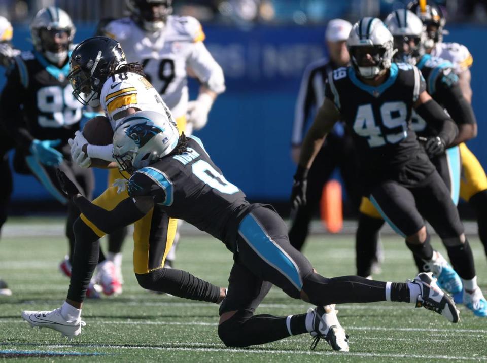 Pittsburgh Steelers wide receiver Diontae Johnson (18), left, is tackled by Carolina Panthers cornerback Jaycee Horn (8) at the Bank of America Stadium in Charlotte, N.C., on Sunday, December 18, 2022.