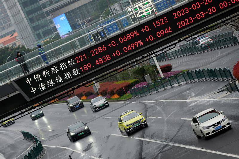 FILE PHOTO: An electronic board shows stock indexes at the Lujiazui financial district in Shanghai